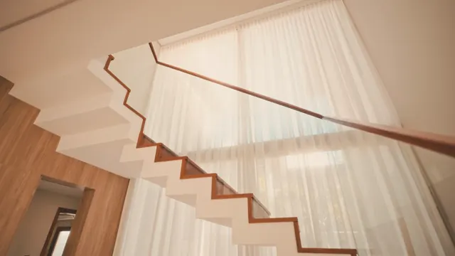 Escalier en bois et voilages de lin dans une maison lumineuse