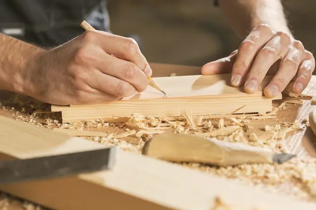 Artisan traçant une coupe sur une planche de bois