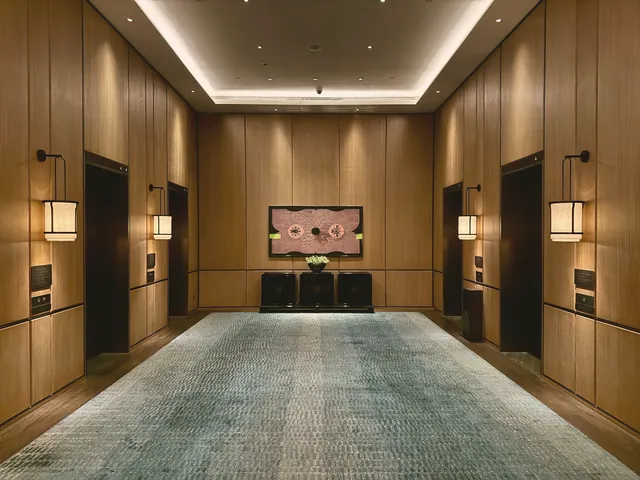 Couloir d’hôtel boisé éclairé par des appliques