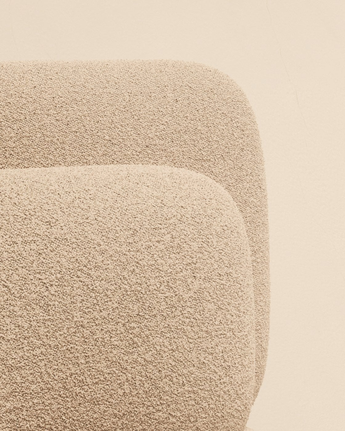 Gros plan d’un tissu bouclette écru sur les courbes d’un fauteuil