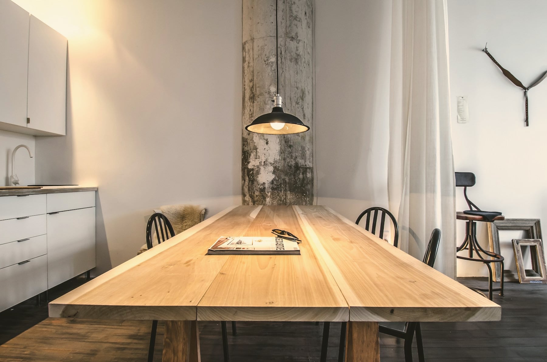 Grande table en bois massif à lames, suspension métal et chaises noires